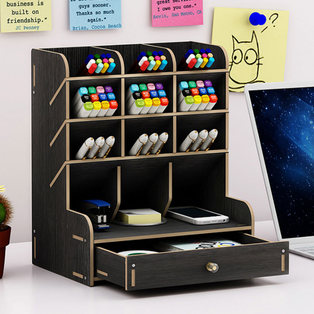 Black wooden desk organizer with stationery items on a desk.