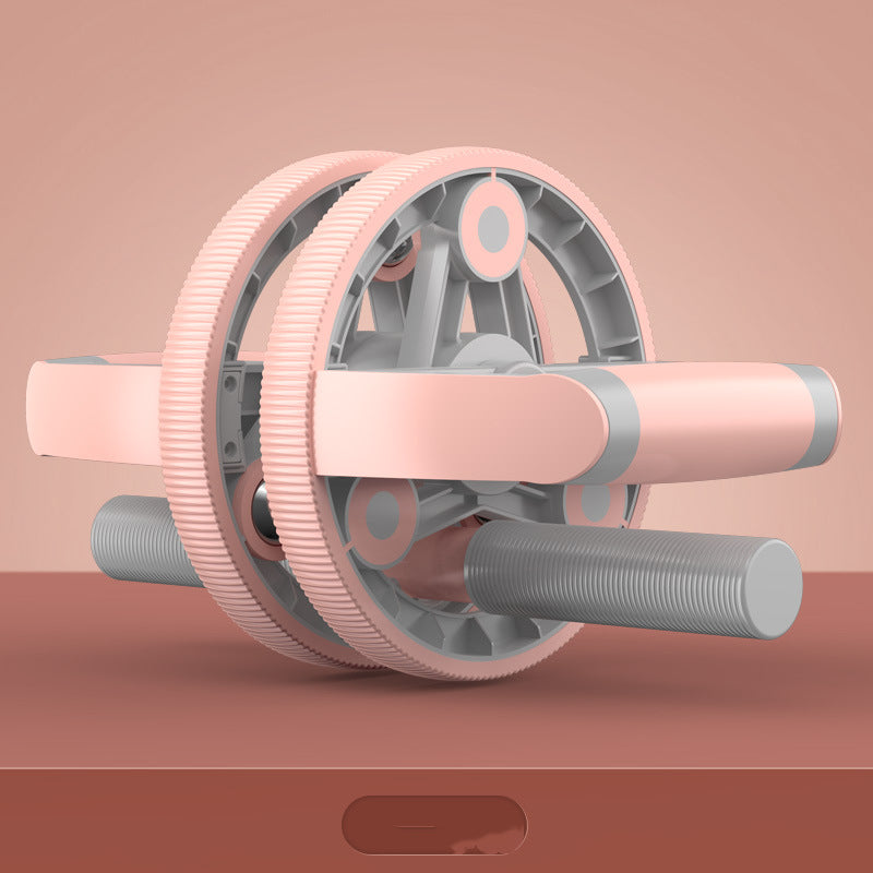 Pink and gray ab roller on a pink background
