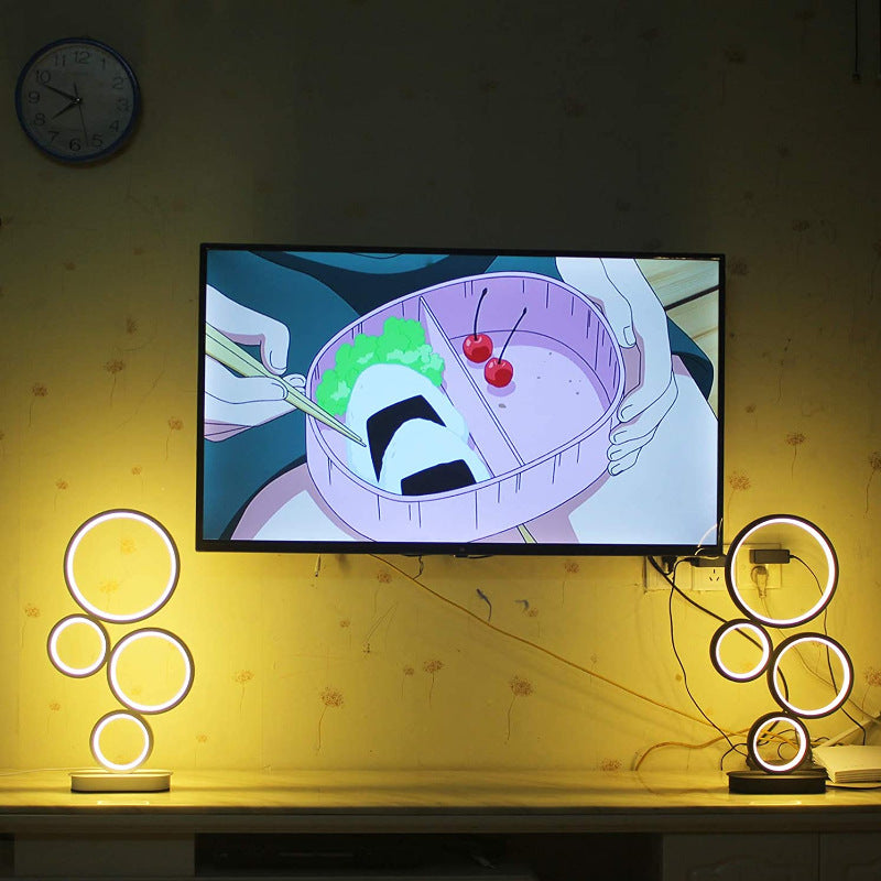 Cartoon on a television screen with two decorative lamps on either side.