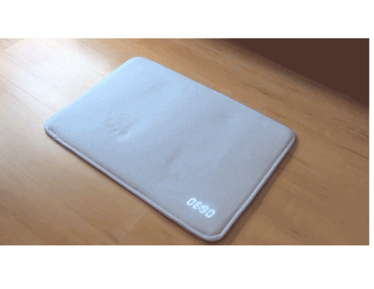 Gray bath mat with 'DECO' branding on a wooden floor