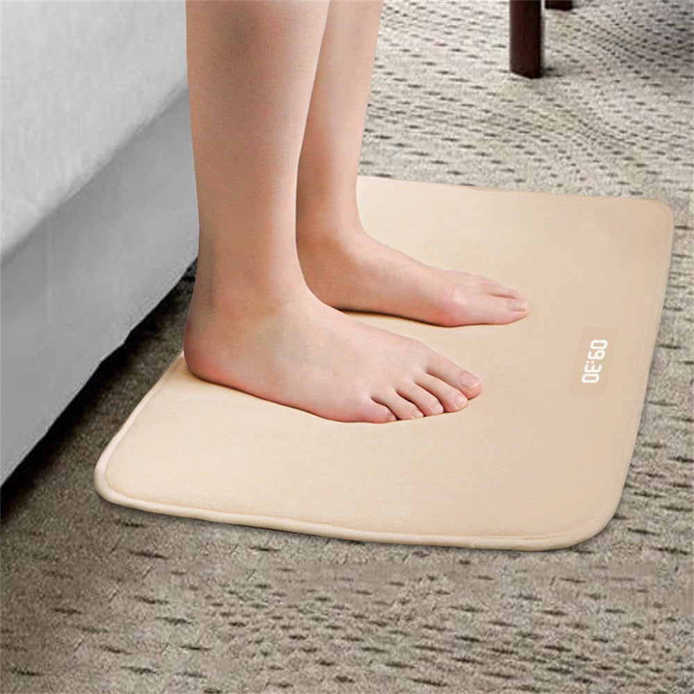 Beige bath mat with feet stepping onto it on a textured floor.