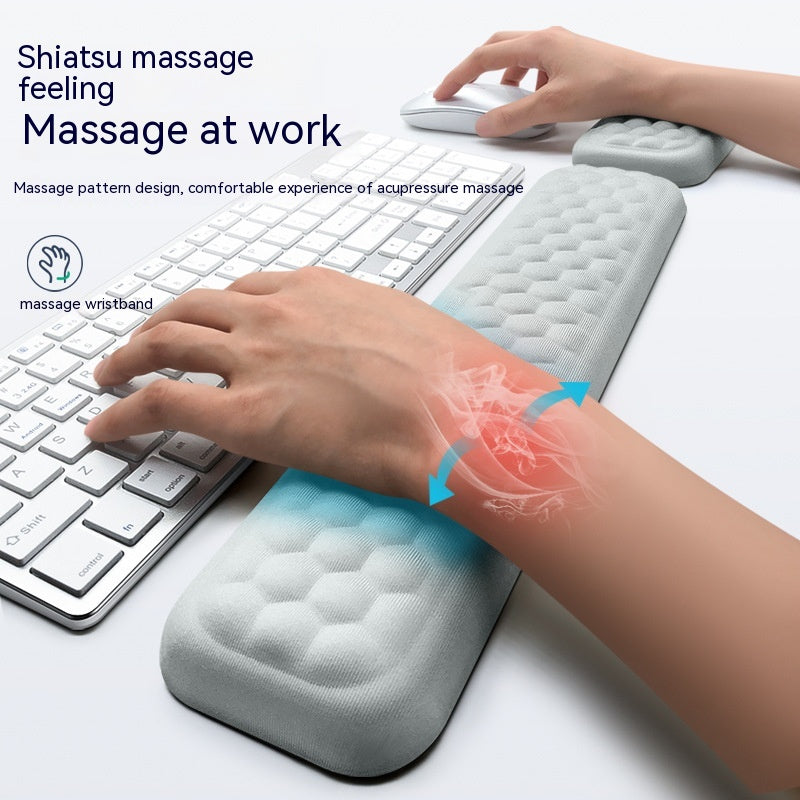 Massage wristband being used with a keyboard and mouse on a desk, highlighting its acupressure massage feature.