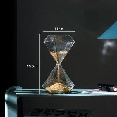Glass hourglass with sand being poured, showing dimensions on a dark background
