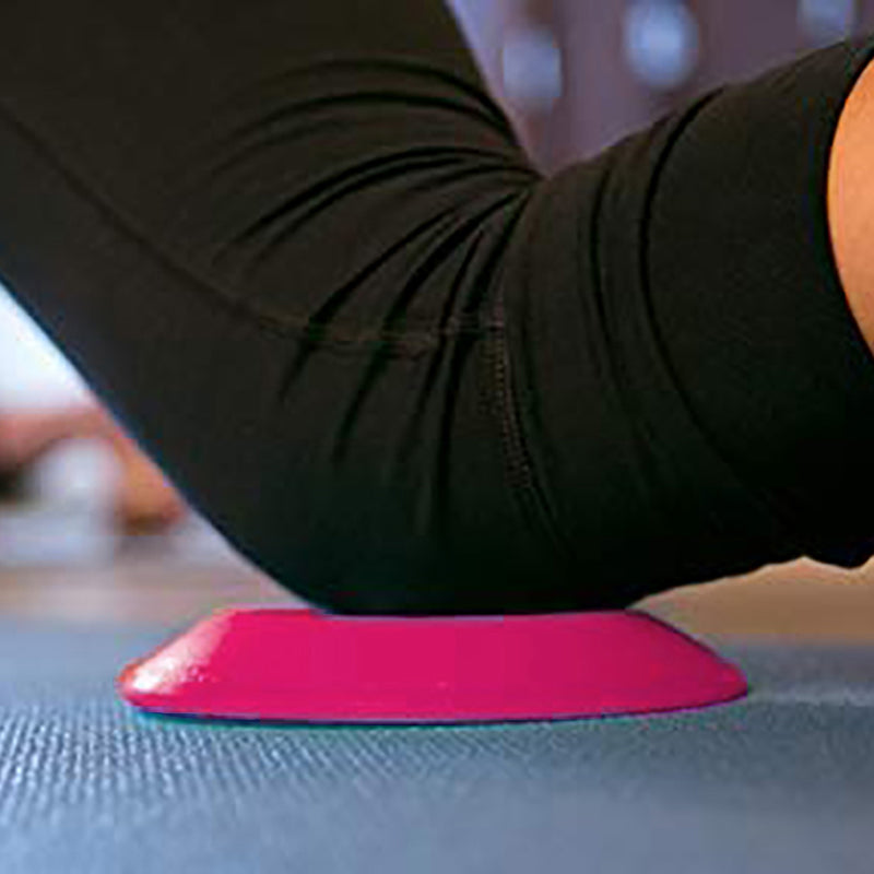 Person using a pink foam roller on a blue exercise mat.