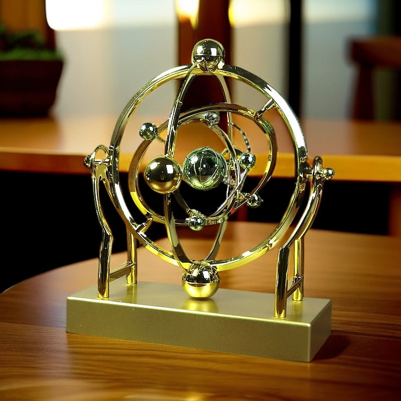 Gold atom model sculpture on a wooden surface