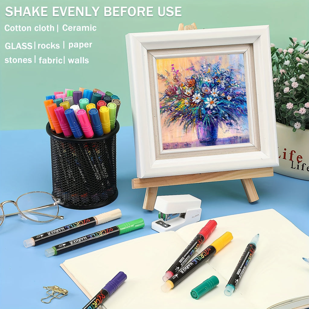 Colorful markers with a painting on an easel and stationery items on a blue surface.