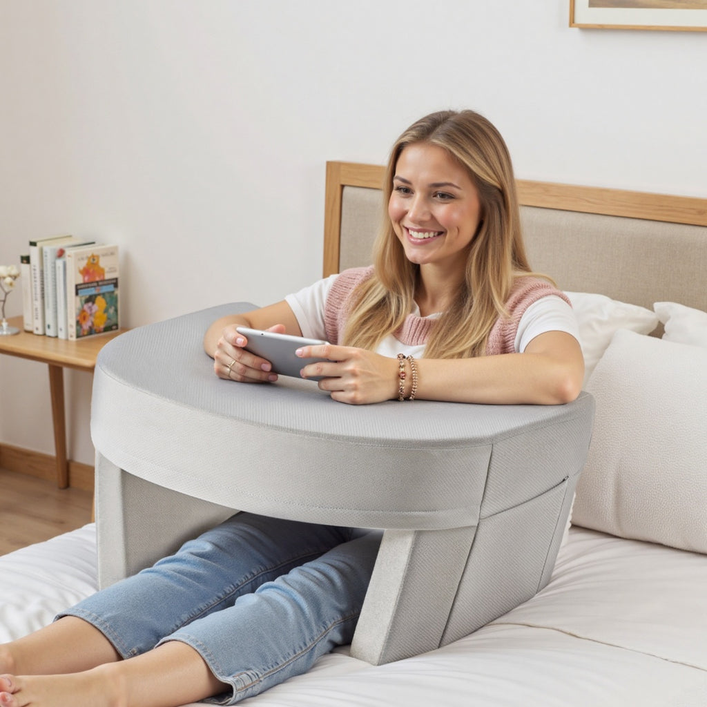Woman using a tablet on a round gray table in a bedroom