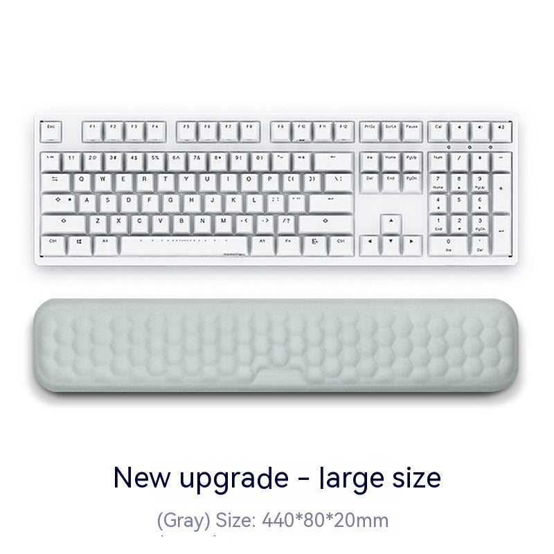 White keyboard with a gray wrist pad on a white background