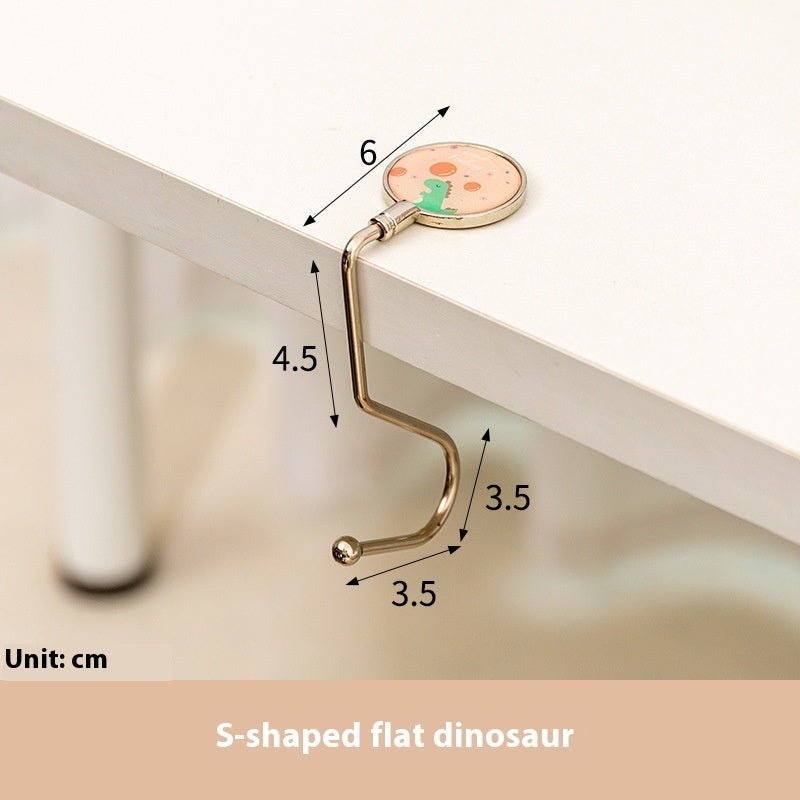 S-shaped flat dinosaur toy with measurements on a white surface