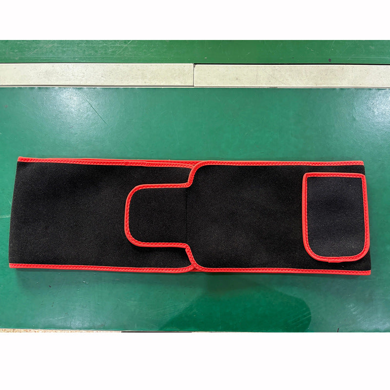 Black car mat with red trim on a green surface