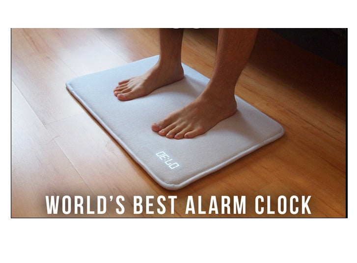 Person standing on a smart scale with 'World's Best Alarm Clock' text
