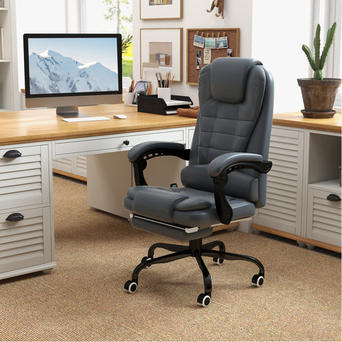 Gray office chair in front of a wooden desk with a computer setup.