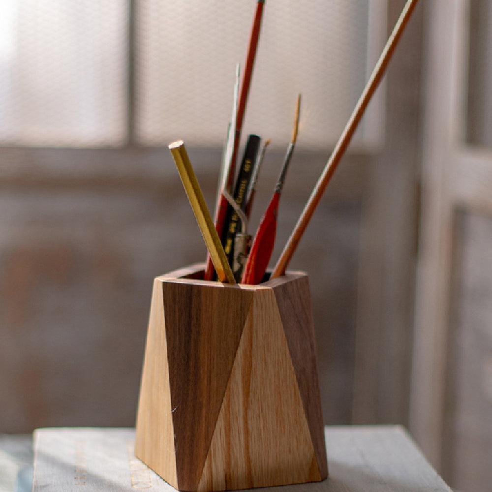 Wooden vase with sticks and brushes on a blurred background