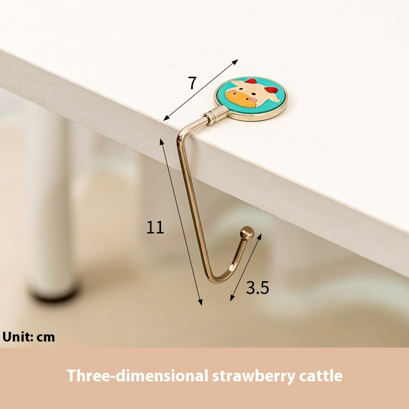 Gold hook with three-dimensional strawberry cattle design, showing measurements on a white surface.