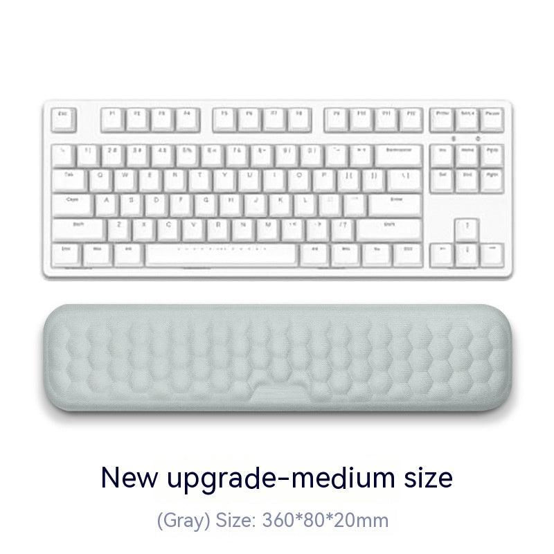 White keyboard with a gray wrist pad on a white background