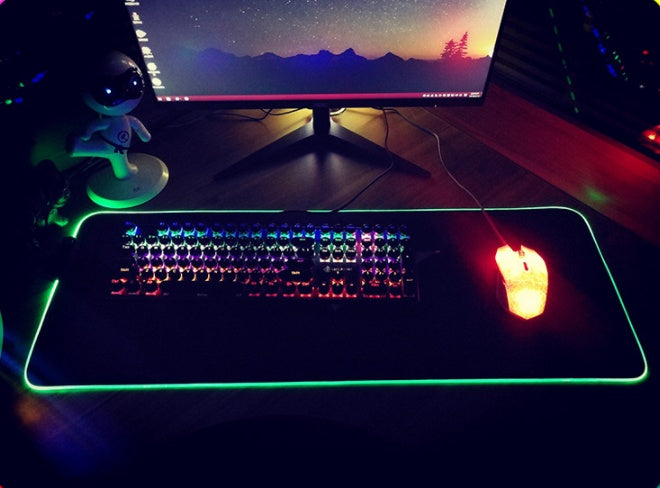 Gaming setup with RGB keyboard, mouse, and monitor on a desk.