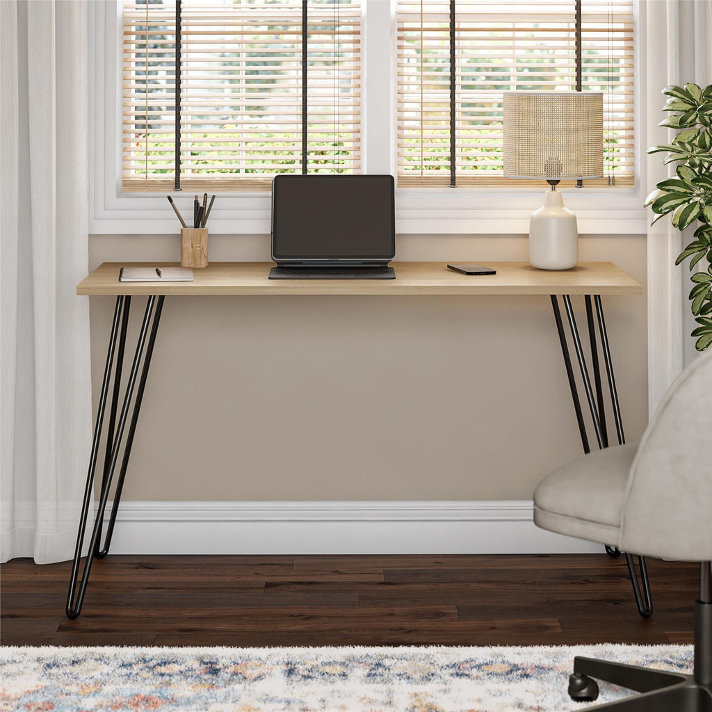 Wooden desk with black hairpin legs in a home office setting.