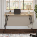 Wooden desk with black hairpin legs in a home office setting.