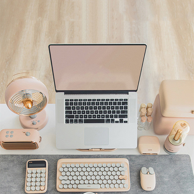 Laptop on a desk with keyboard, mouse, and decorative items.