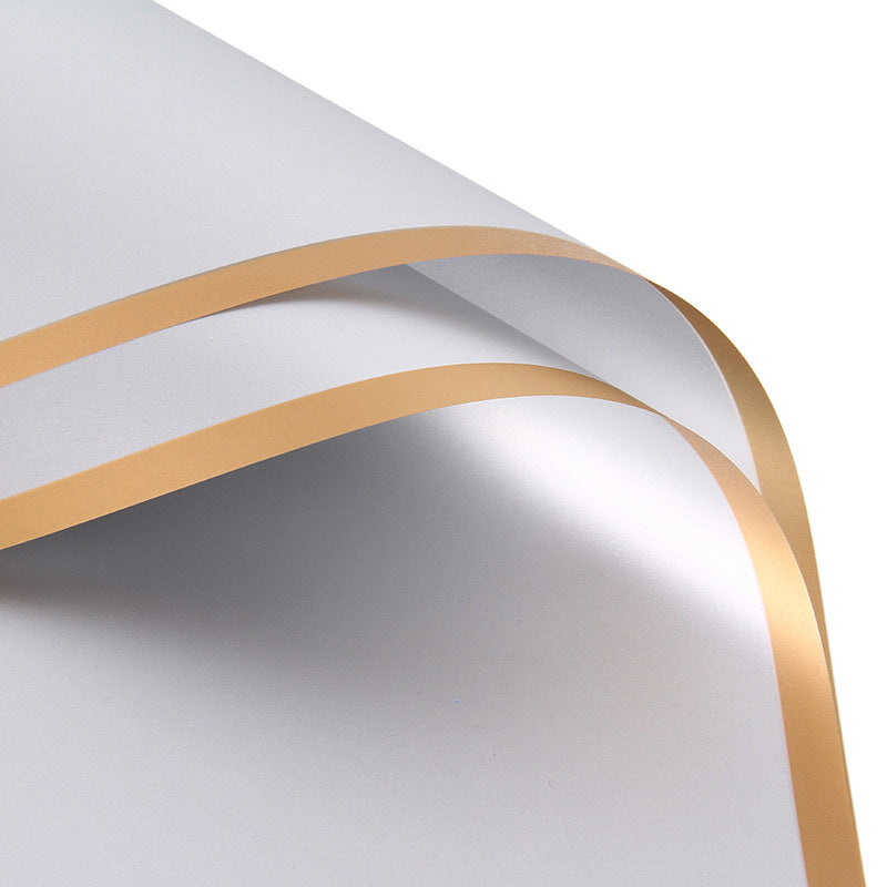 White paper with gold edges on a white background