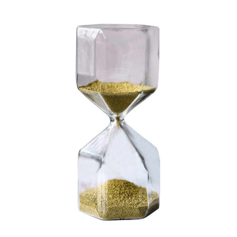 Clear hourglass with gold sand on a white background