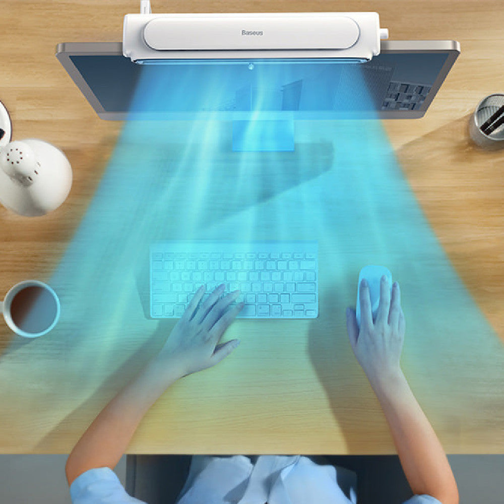 Person using a transparent keyboard and mouse on a wooden desk with a futuristic light display.