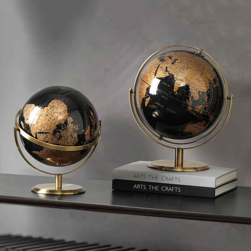 Two decorative globes on a shelf with a gray background