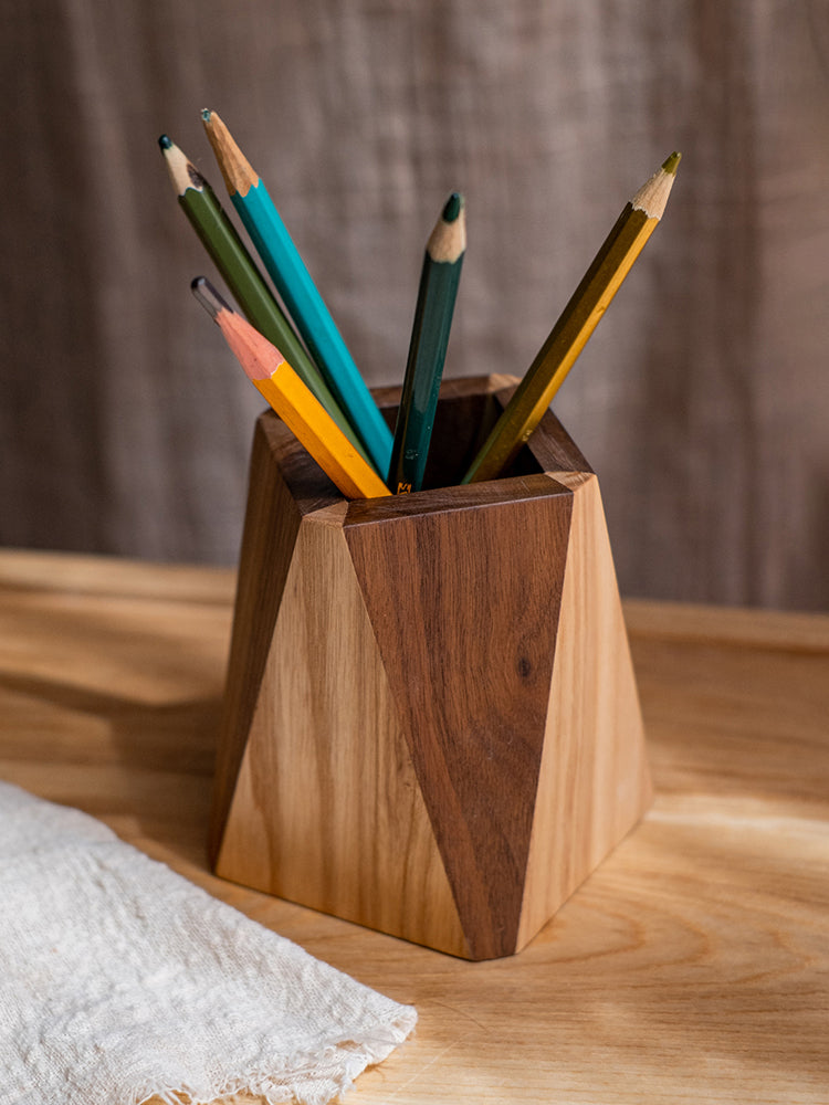 Wooden pencil holder with colorful pencils on a wooden surface