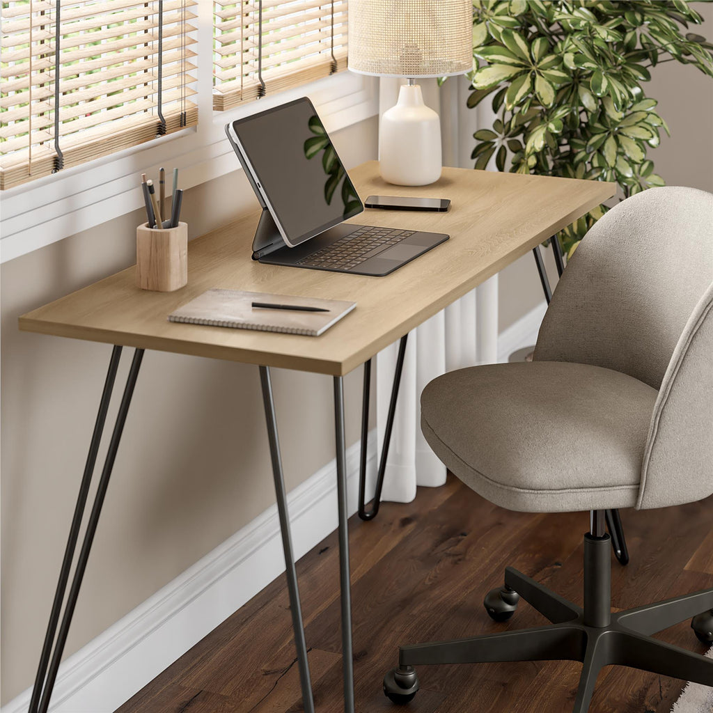 Home office setup with a wooden desk, chair, laptop, and decor items.